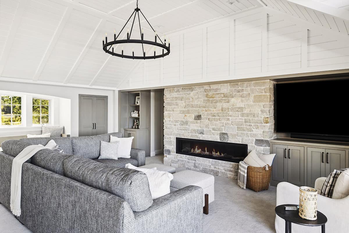 Stone fireplace wall with wheel chandelier in family room