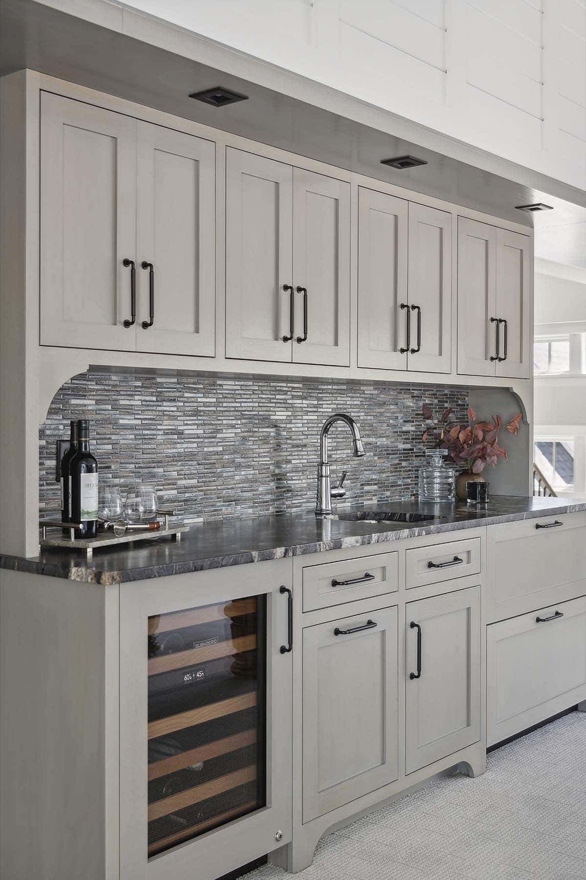 Wet bar with gray cabinetry, mosaic tile backsplash, and wine fridge