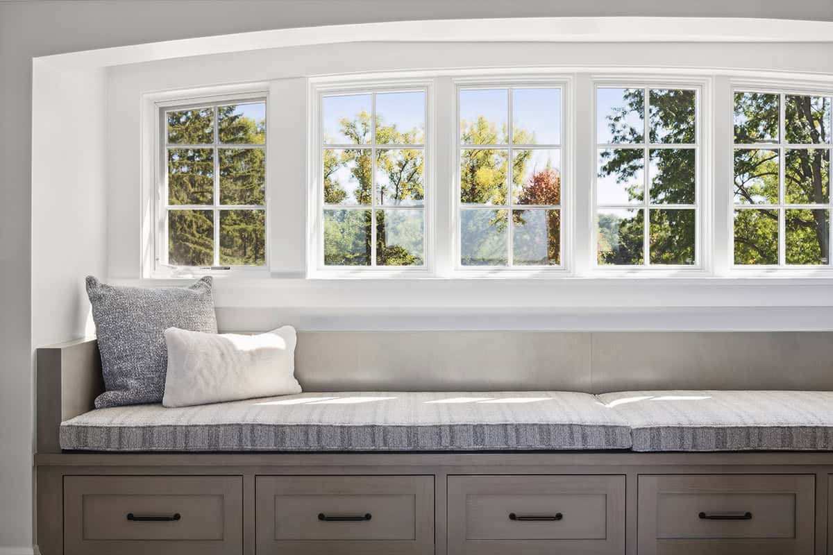 Built-in window seat beneath arched five-window bank
