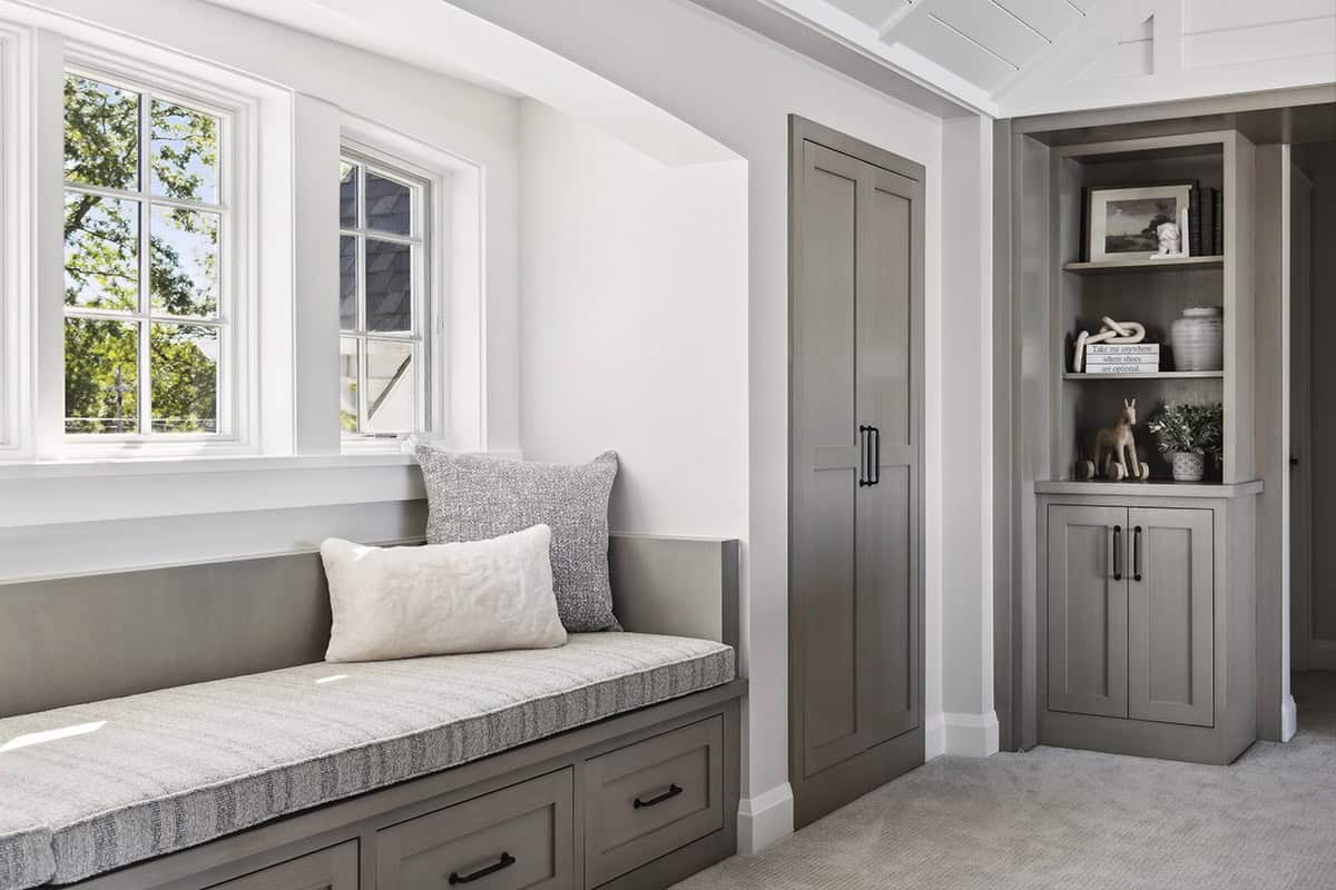 Window seat nook beside closet and open shelving