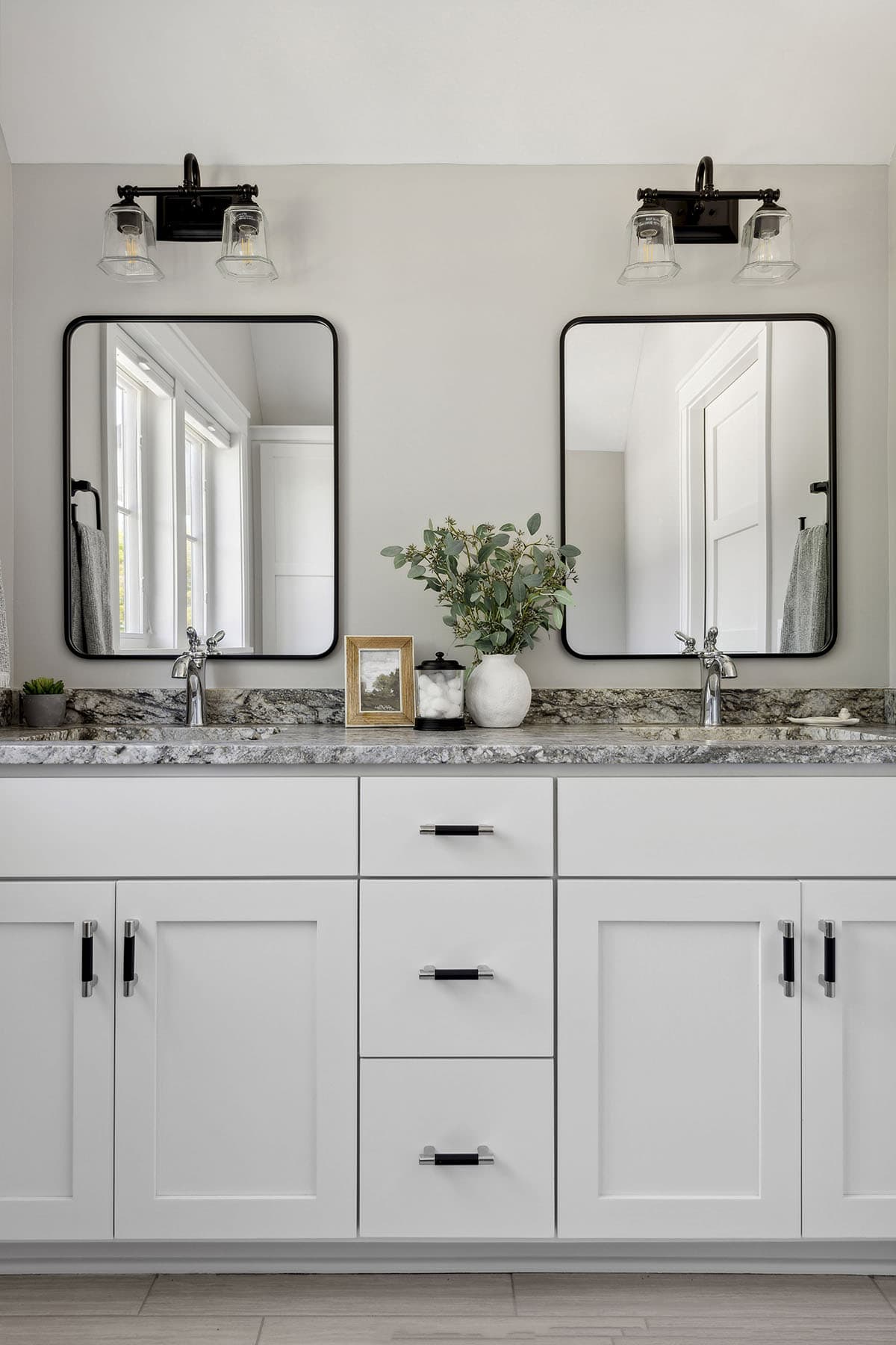 Close-up of double vanity mirrors and granite countertop