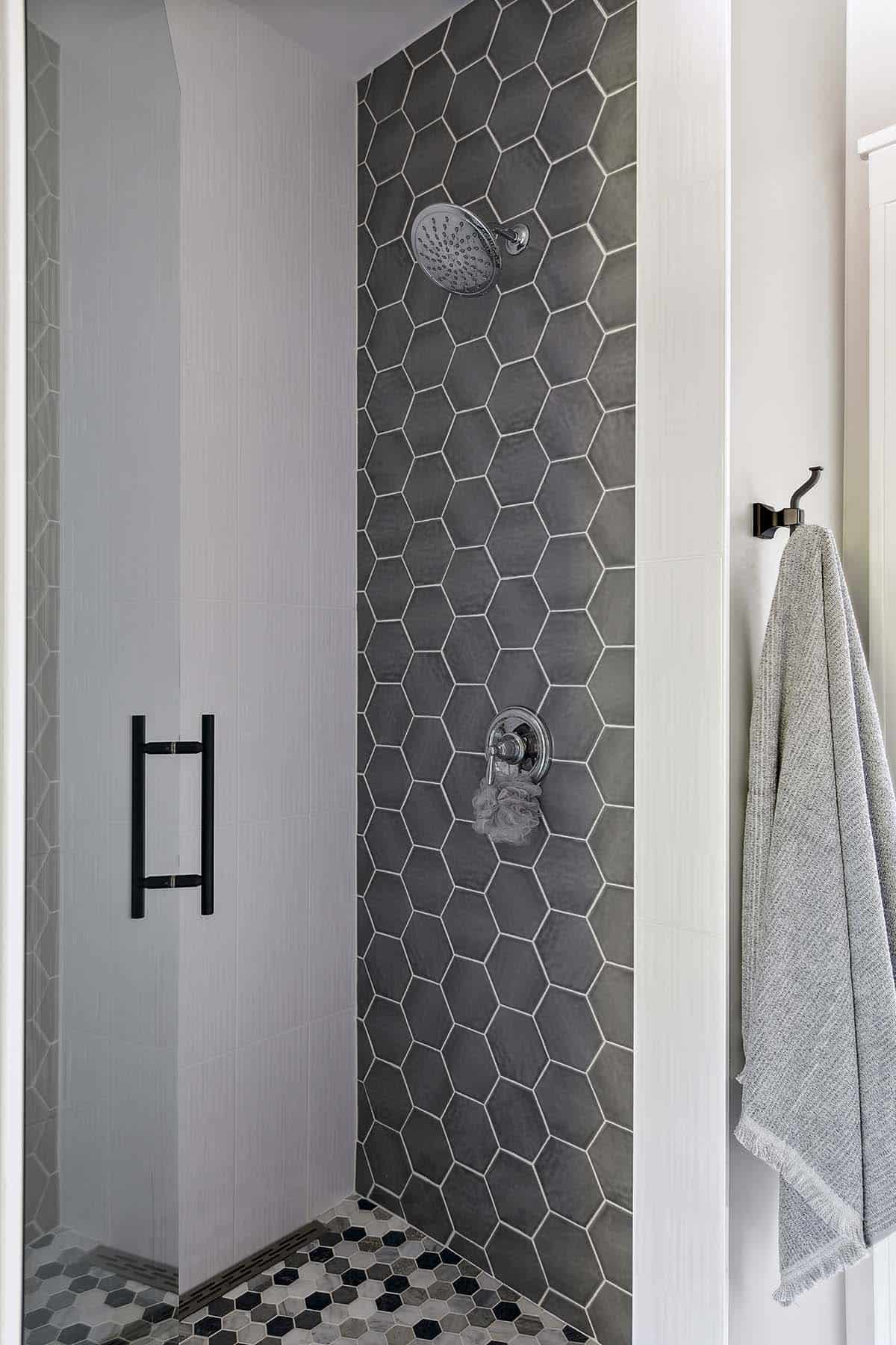 Gray hexagon tile shower with chrome fixtures