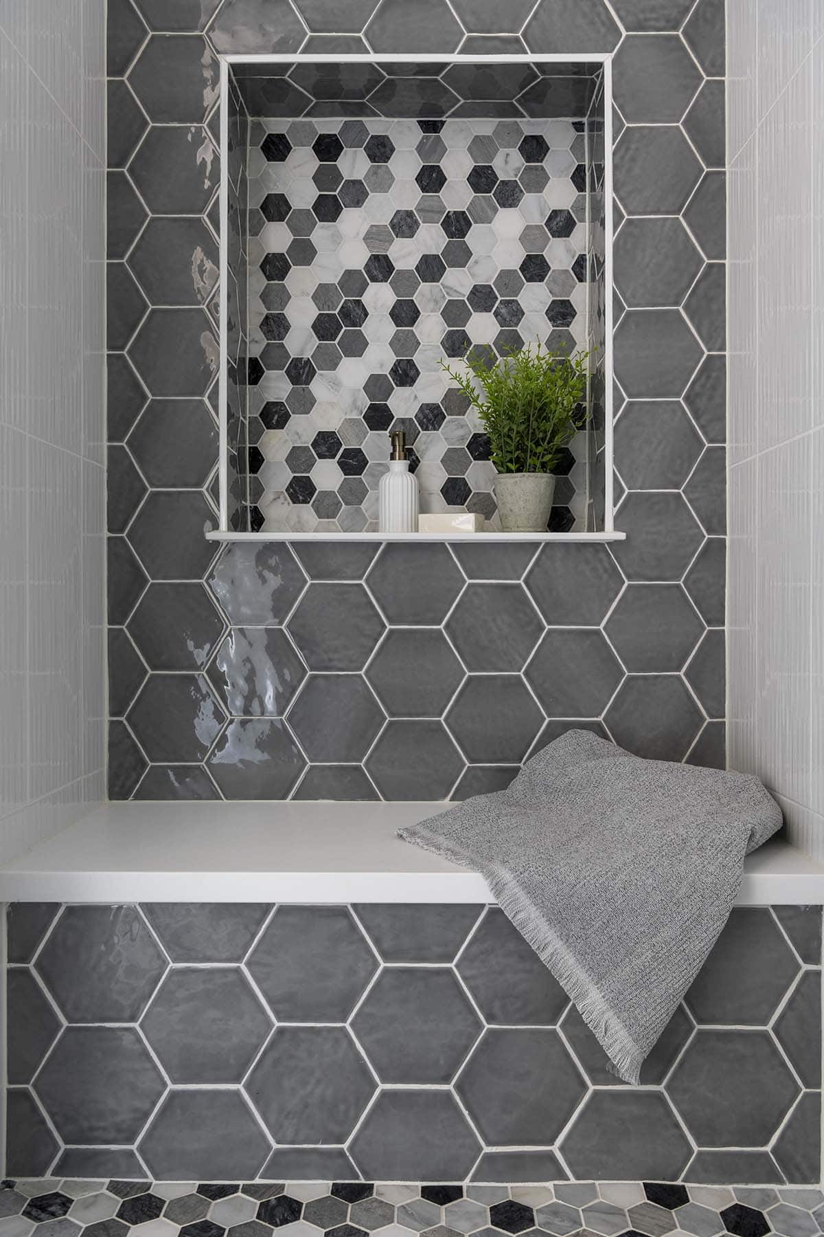 Hexagon tile shower niche and bench with towel