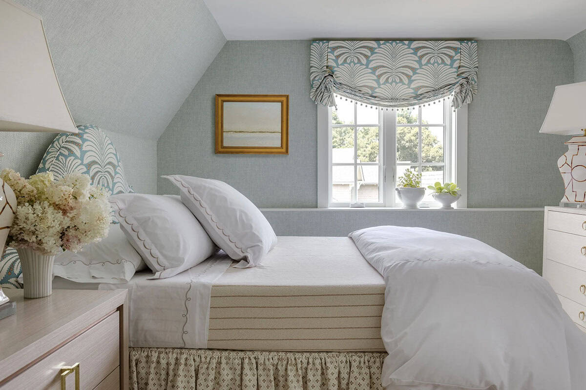 Serene blue-gray bedroom nook with striped headboard and palm-print window valance