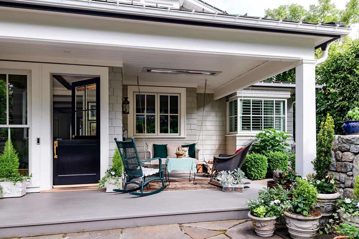 Covered back porch with rocking chairs, porch swing, and potted greenery