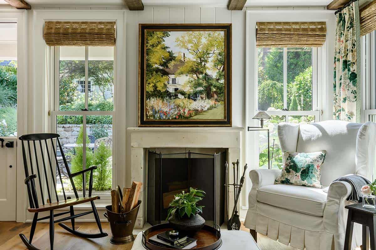Stone fireplace mantel with landscape painting and wingback chair