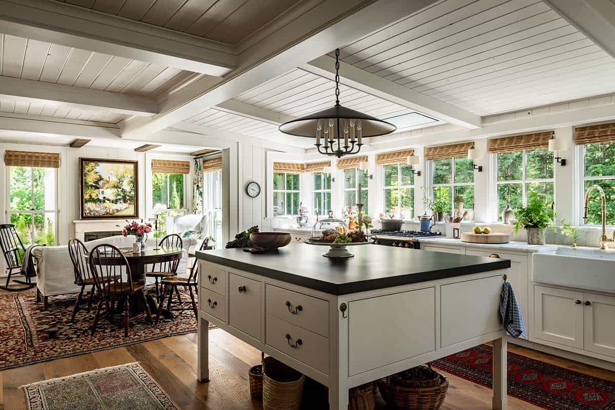Open kitchen and dining area with island, pendant light, and layered rugs