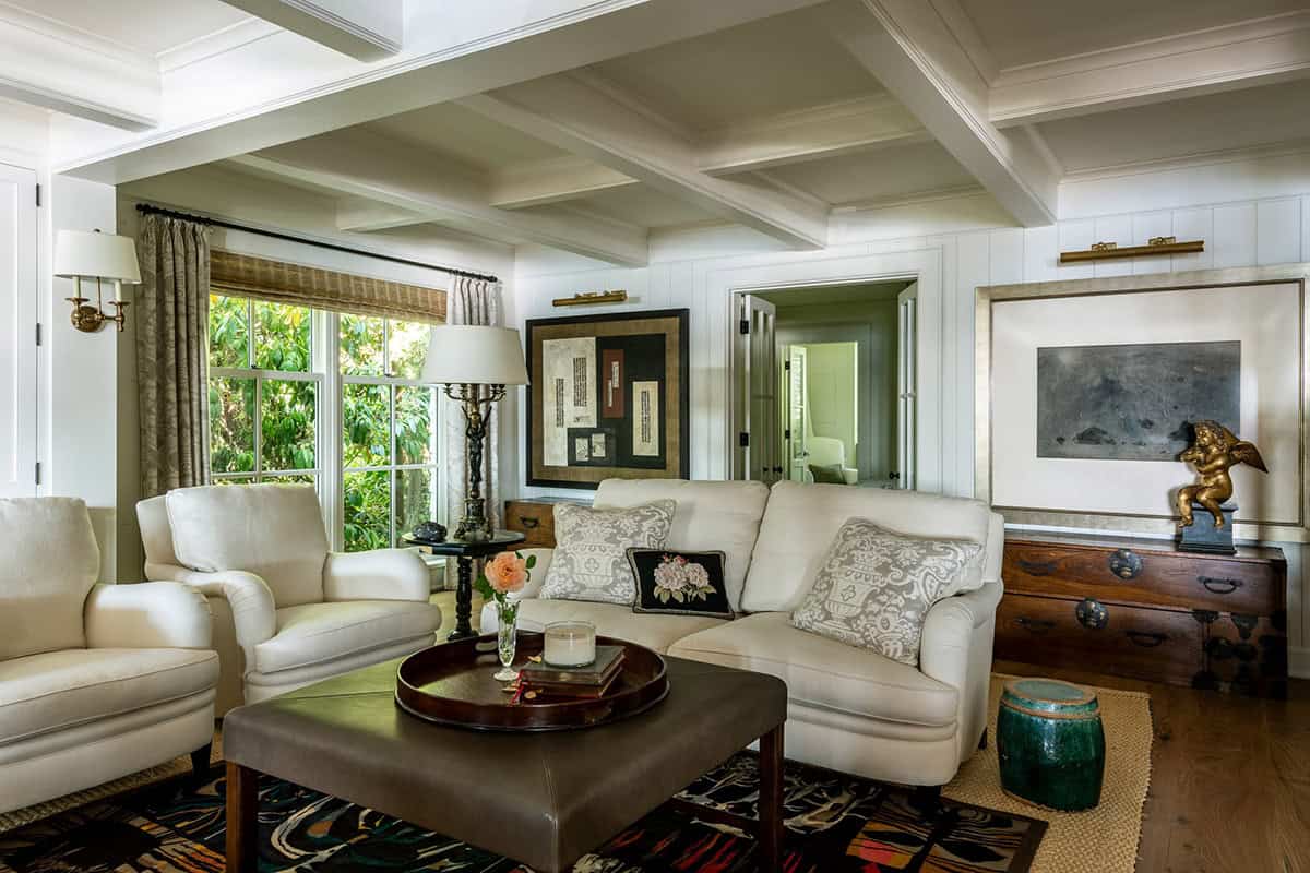 Family room with coffered ceiling, cream sofas, and eclectic artwork