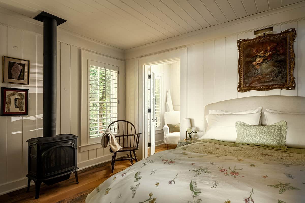 Bedroom with black wood-burning stove and floral bedding