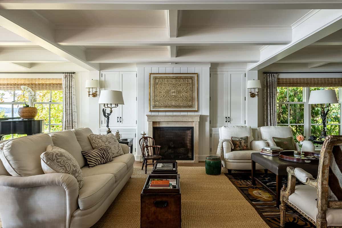 Living room with coffered ceiling, stone fireplace, and antique tapestry
