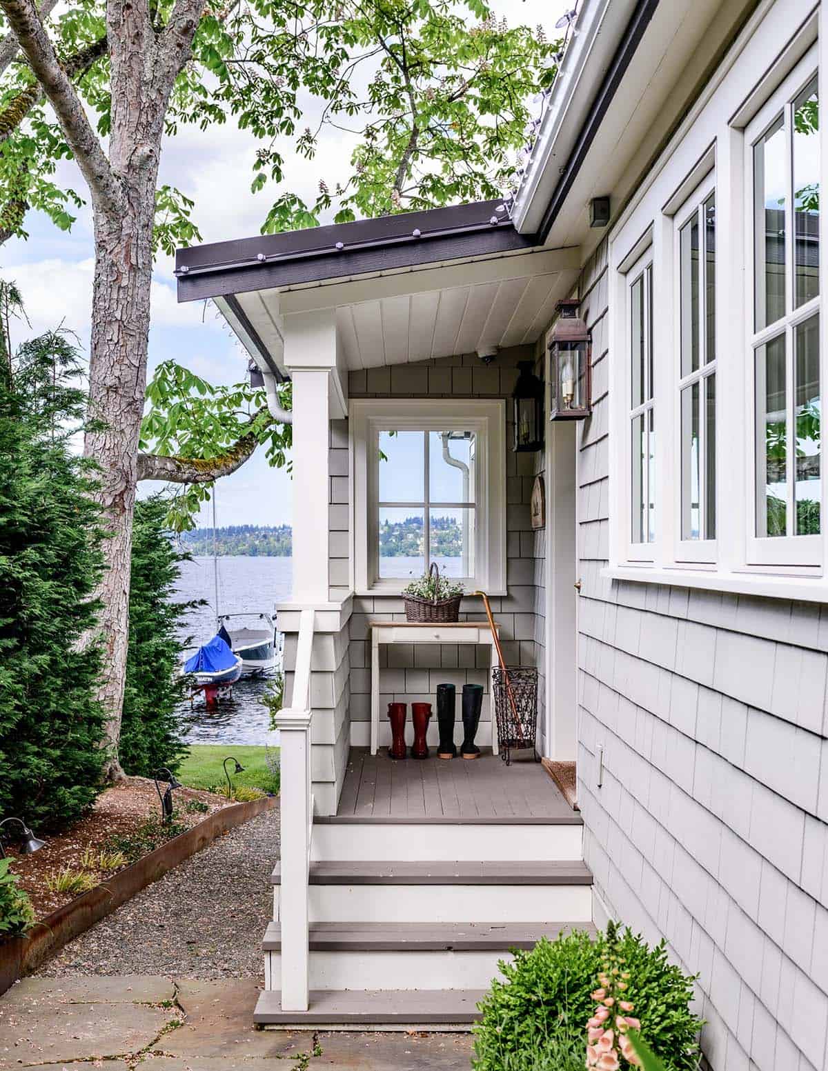 Side entry porch with boot bench overlooking lake and moored boats