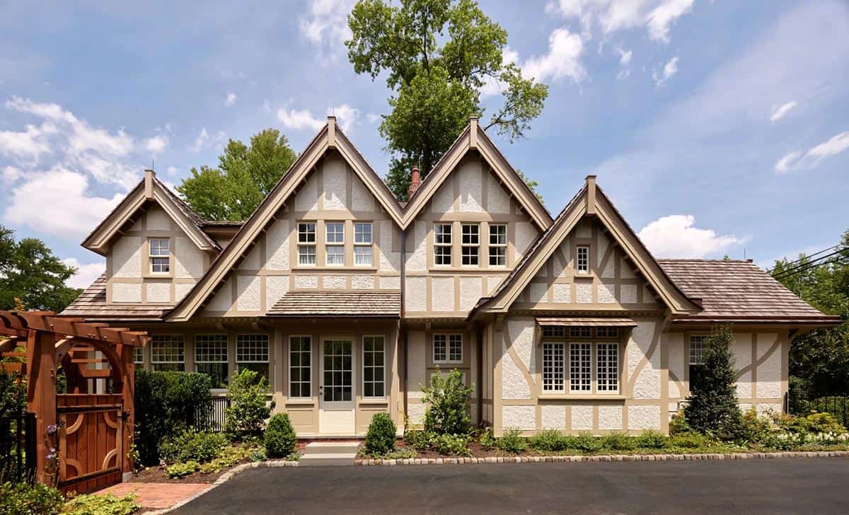 Front facade with three matching steep gables, half-timber detailing, and a paved motor court