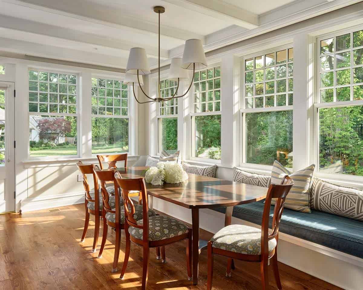 Breakfast nook with wood table, patterned cushions, and a built-in window bench
