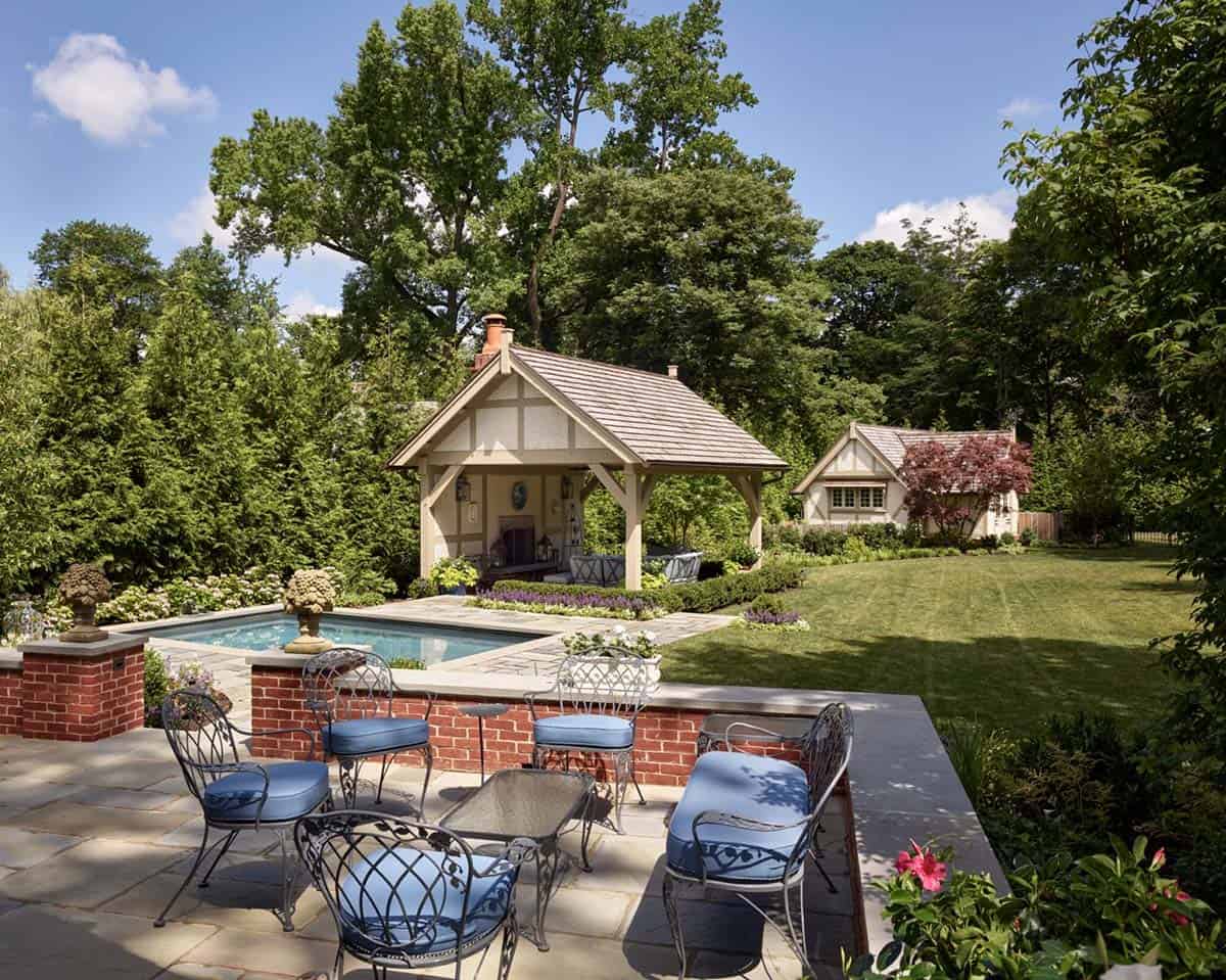 Patio with wrought-iron furniture overlooking the pool, pavilion, and lawn beyond