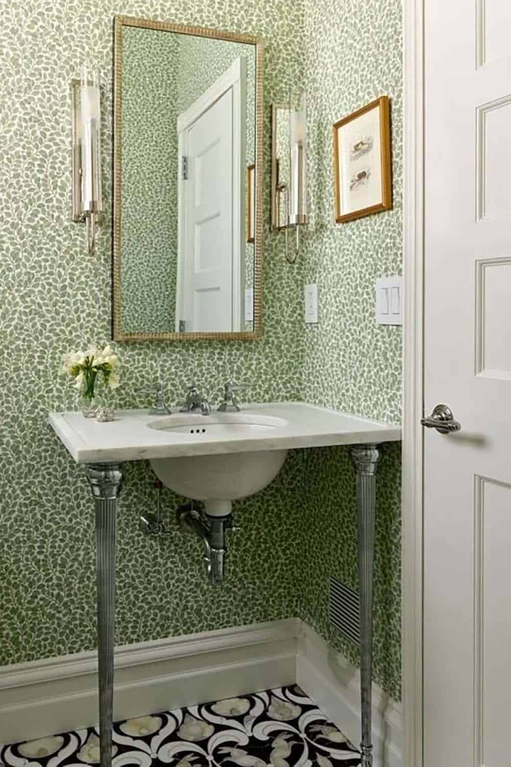Powder room with green leaf-print wallpaper, marble console sink, and patterned tile floor