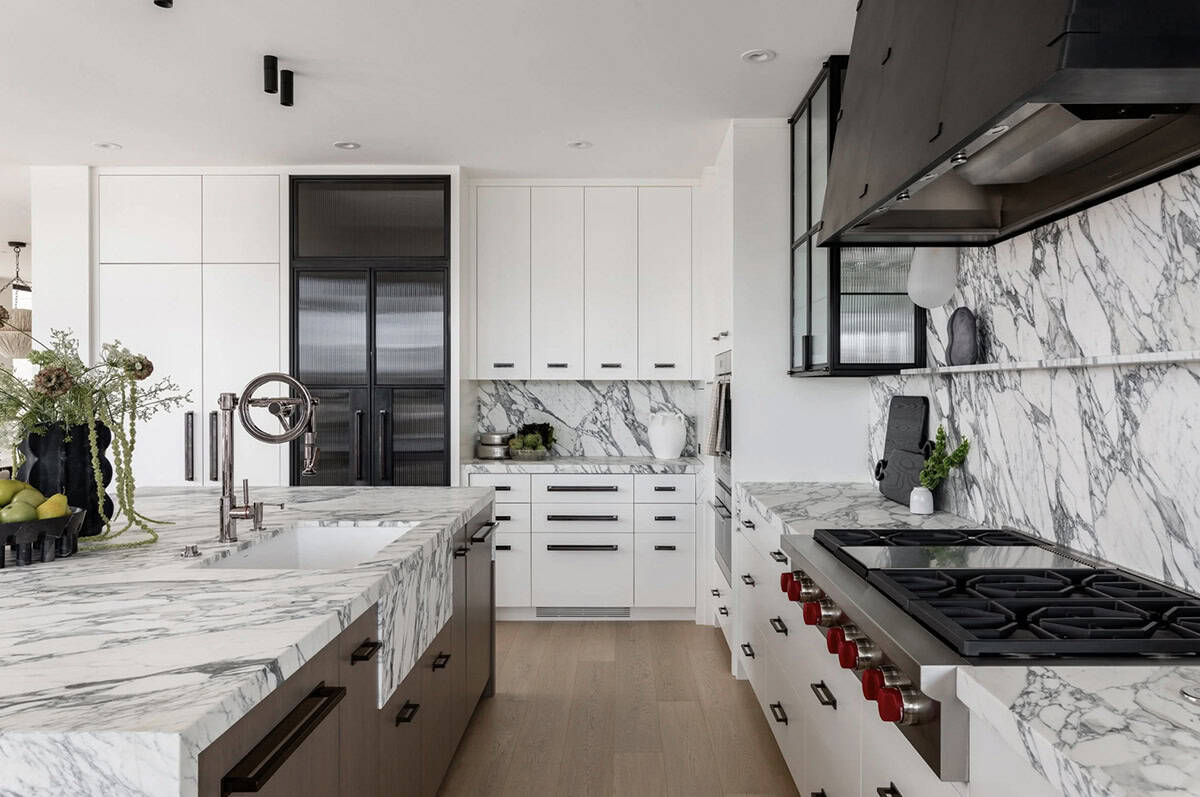 Galley kitchen with marble backsplash, white cabinetry, and black gas range