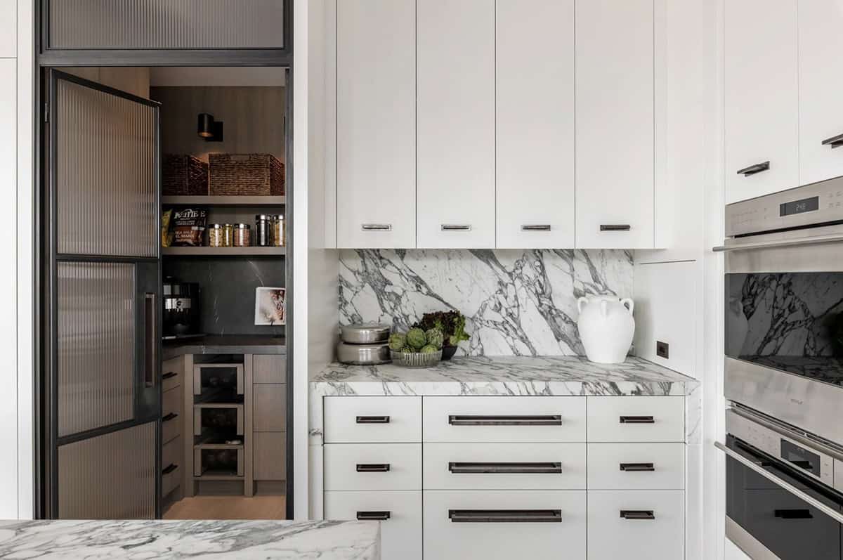 Kitchen pantry entrance with reeded glass doors and marble backsplash