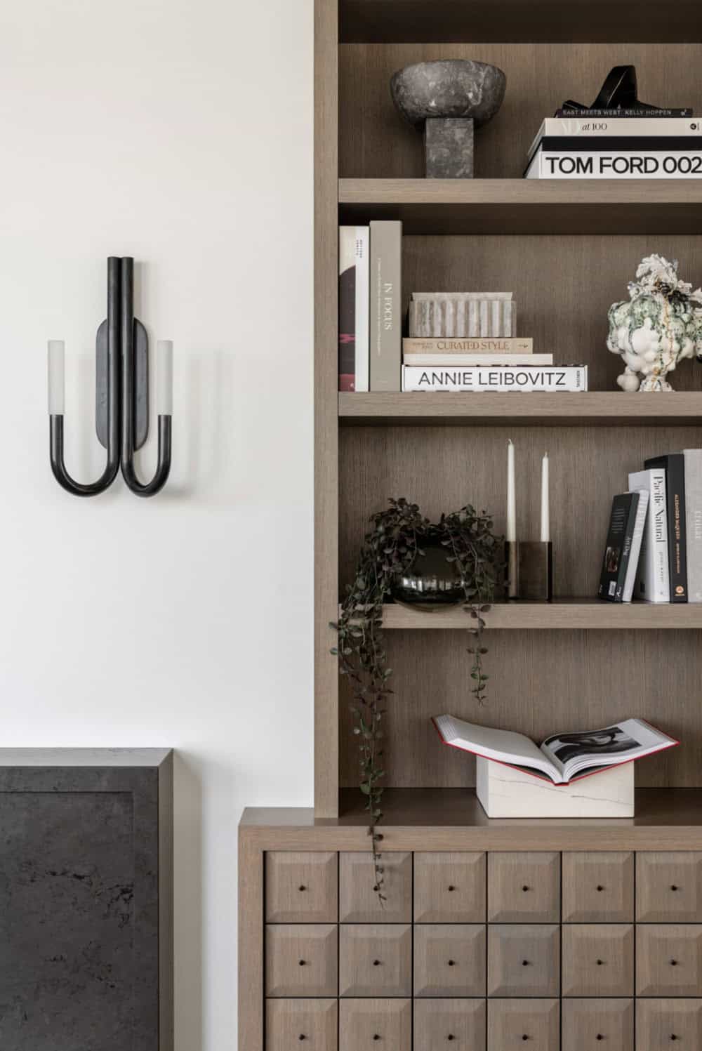 Wall sconce beside built-in bookshelf with styled decor