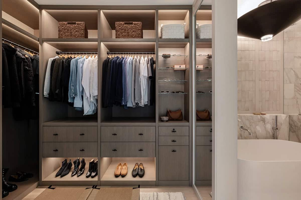 Walk-in closet with built-in shelving and glass sunglass display