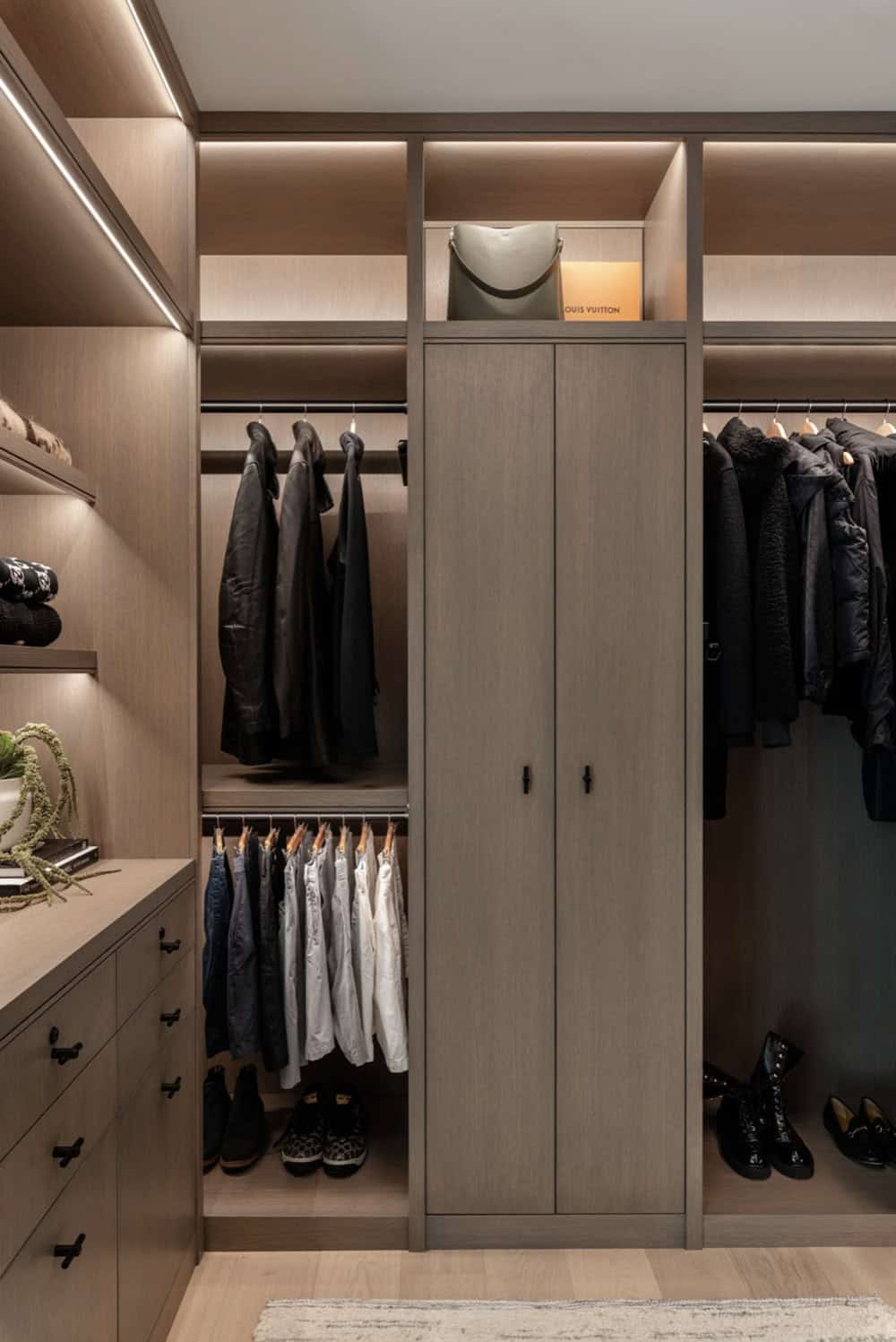 Walk-in closet with hanging storage and Louis Vuitton accessories