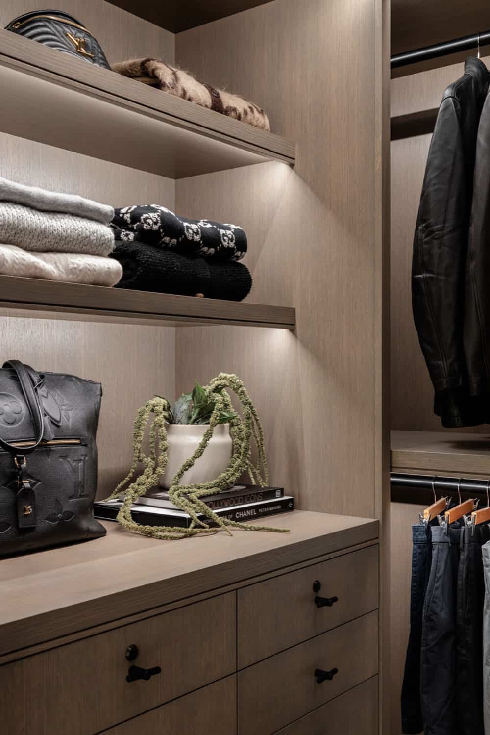 Closet shelving with folded sweaters, handbags, and hanging leather jacket