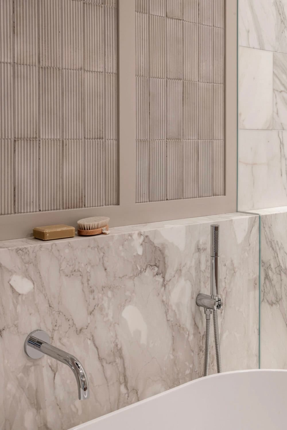 Marble tub surround with handheld shower fixture detail