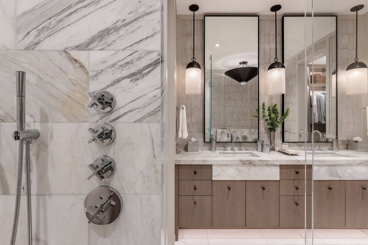 Shower fixture detail beside bathroom vanity with pendant lights