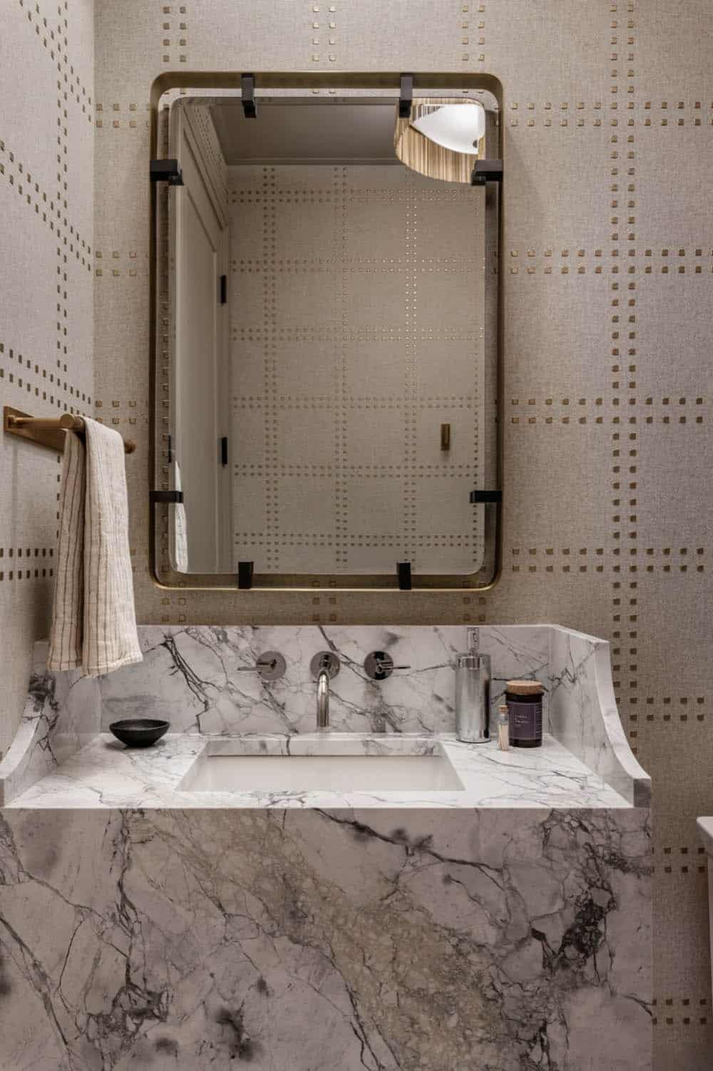 Powder room mirror and marble vanity with brass accents