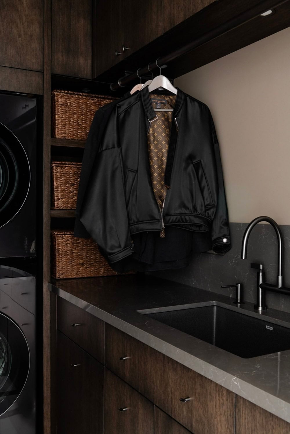 Laundry room shelving with woven baskets and hanging jacket
