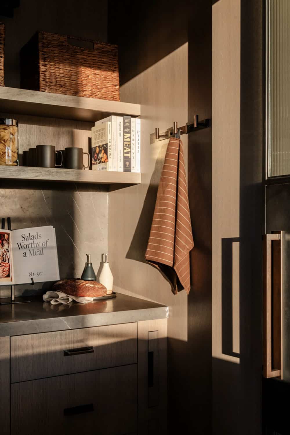 Pantry shelving detail with cookbooks and hanging linen towel