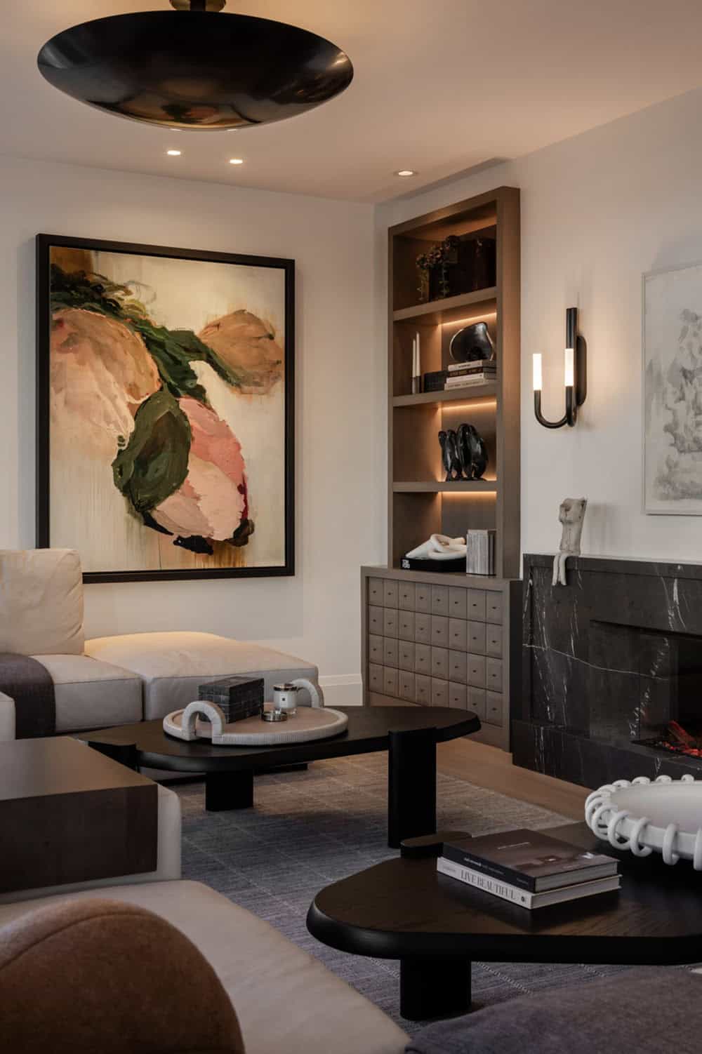 Living room seating with abstract art and black marble fireplace