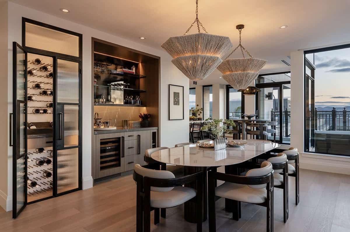 Dining table with woven pendants overlooking wine storage and harbor view