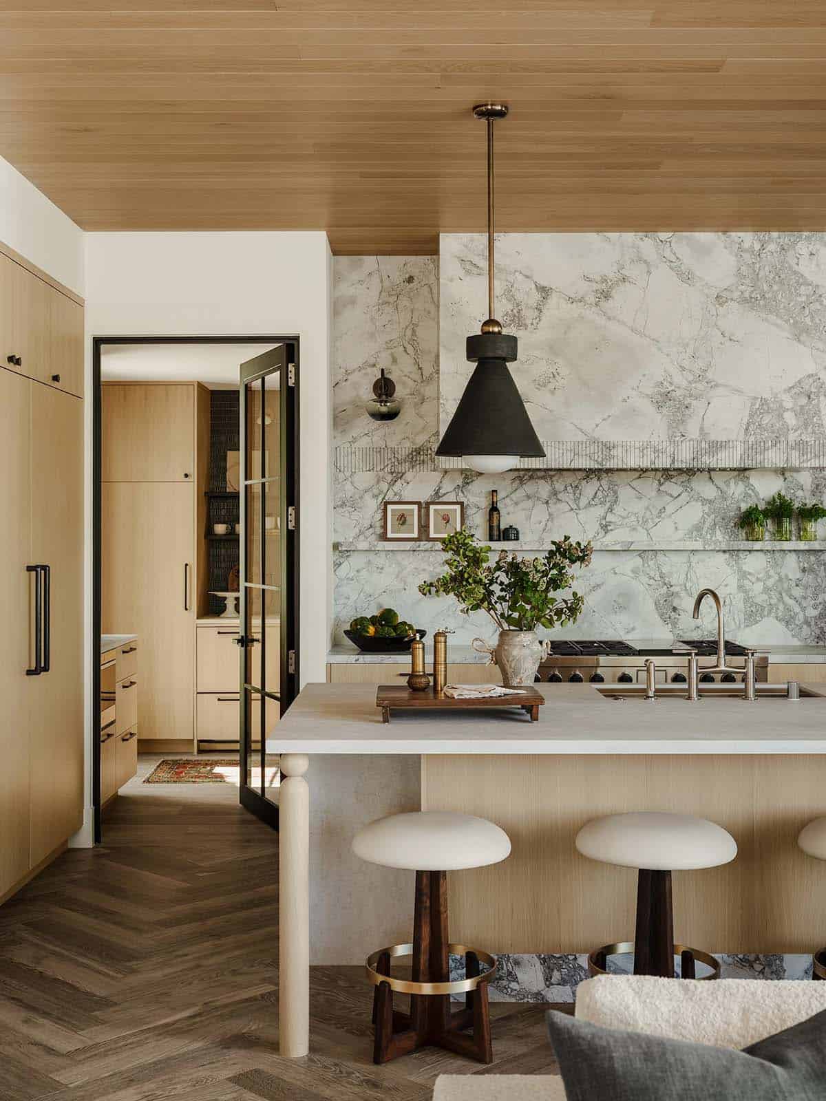 Modern kitchen featuring sleek cabinetry and door leading into the pantry