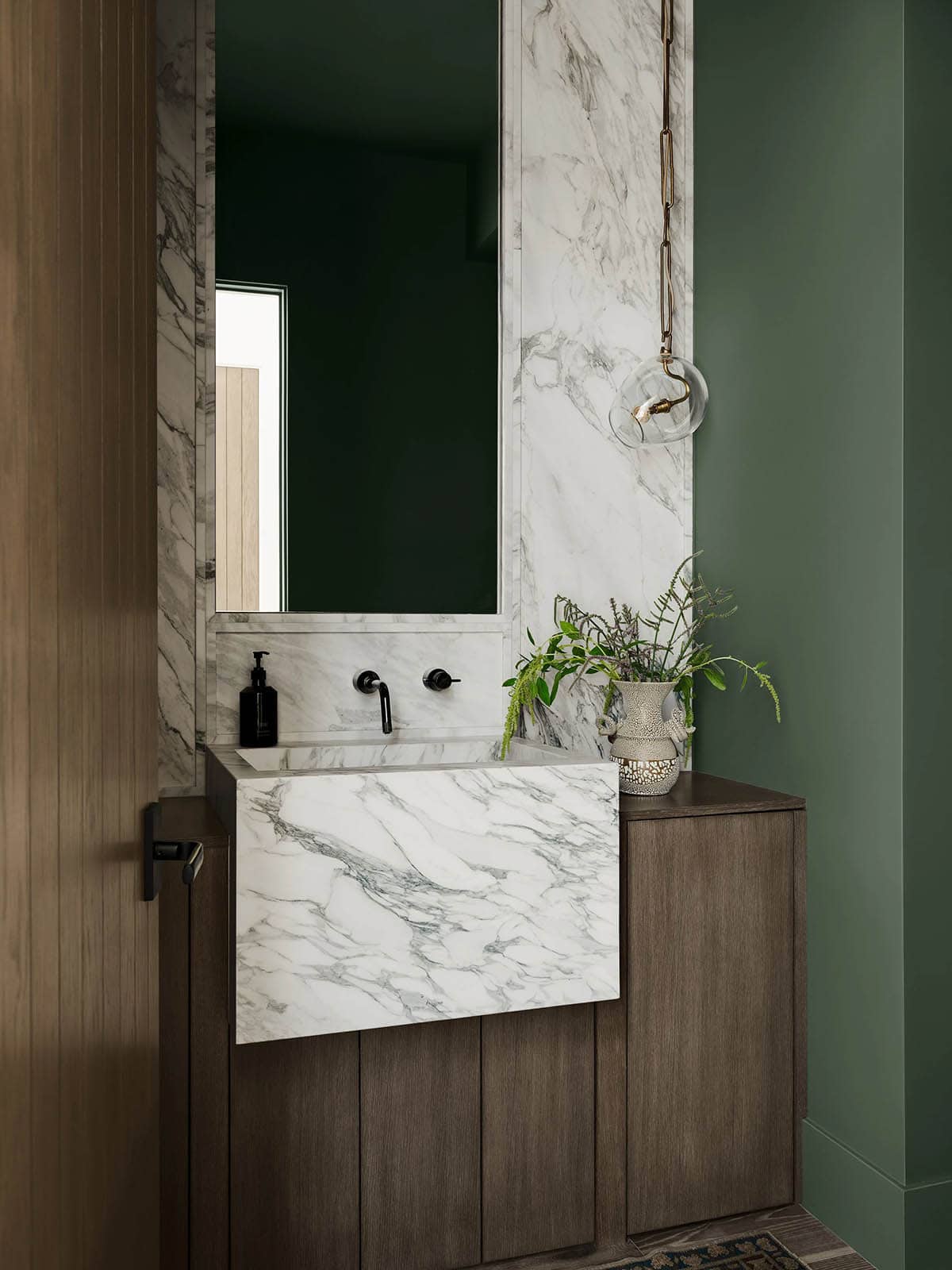 Modern powder room with a stone sink and backsplash wall
