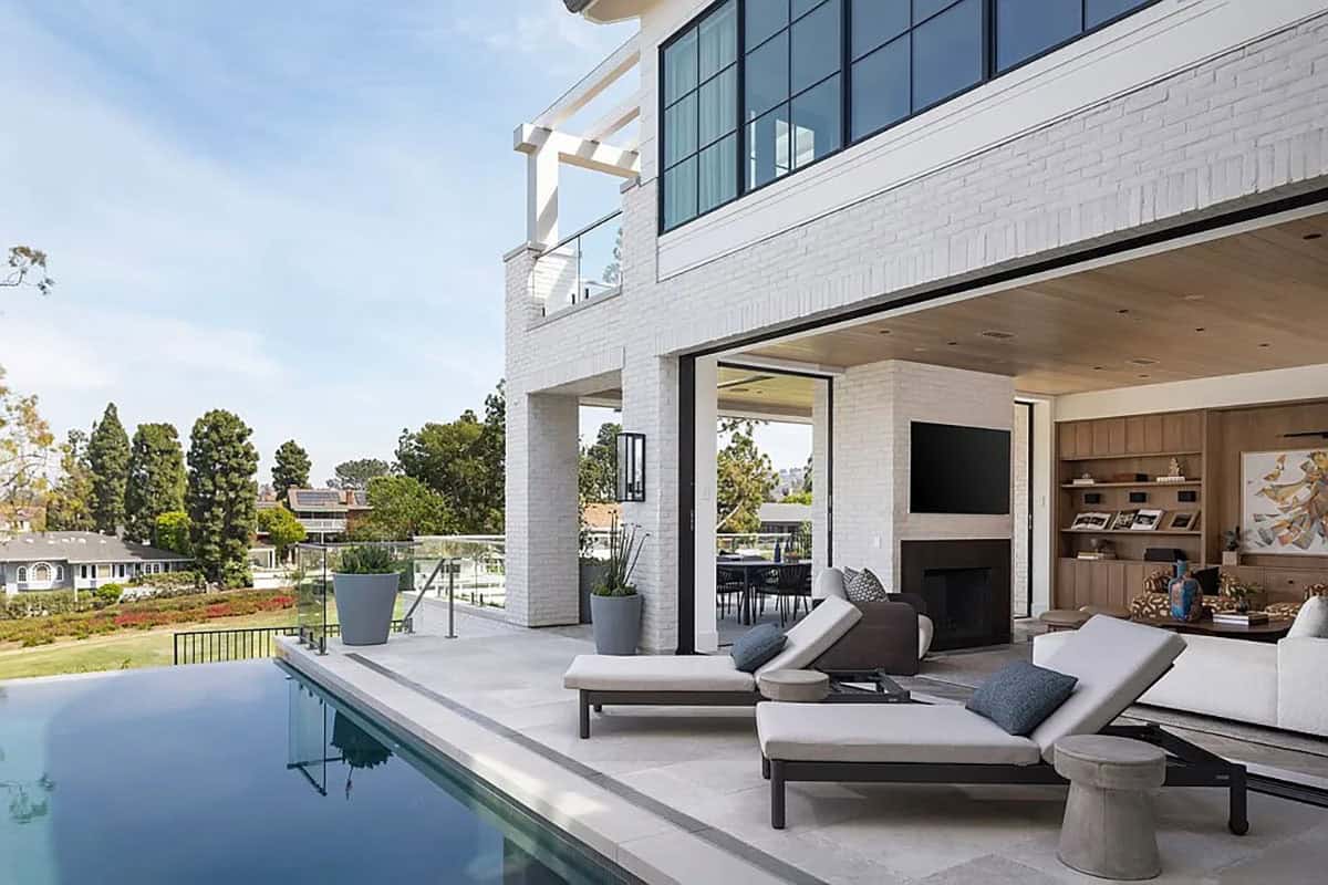 contemporary home exterior with lounge chairs next to a swimming pool