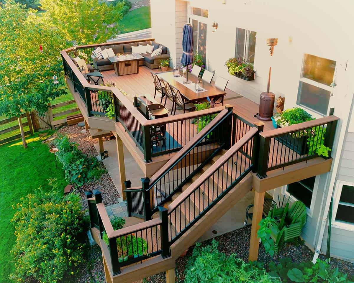 Aerial view of second-story composite deck with dining area, grill, and switchback staircase