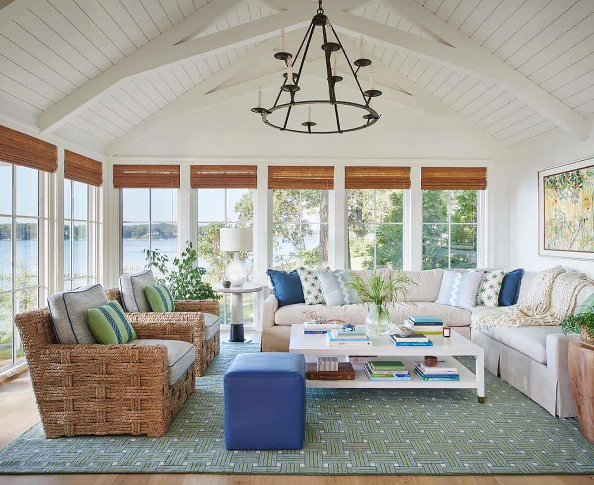 Sunroom with vaulted shiplap ceiling, wicker chairs, and river view