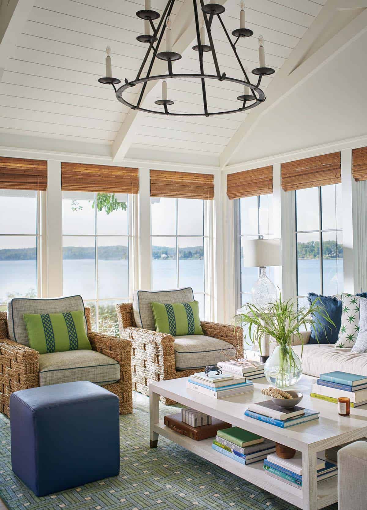 Sunroom seating area with green and blue pillows overlooking the water