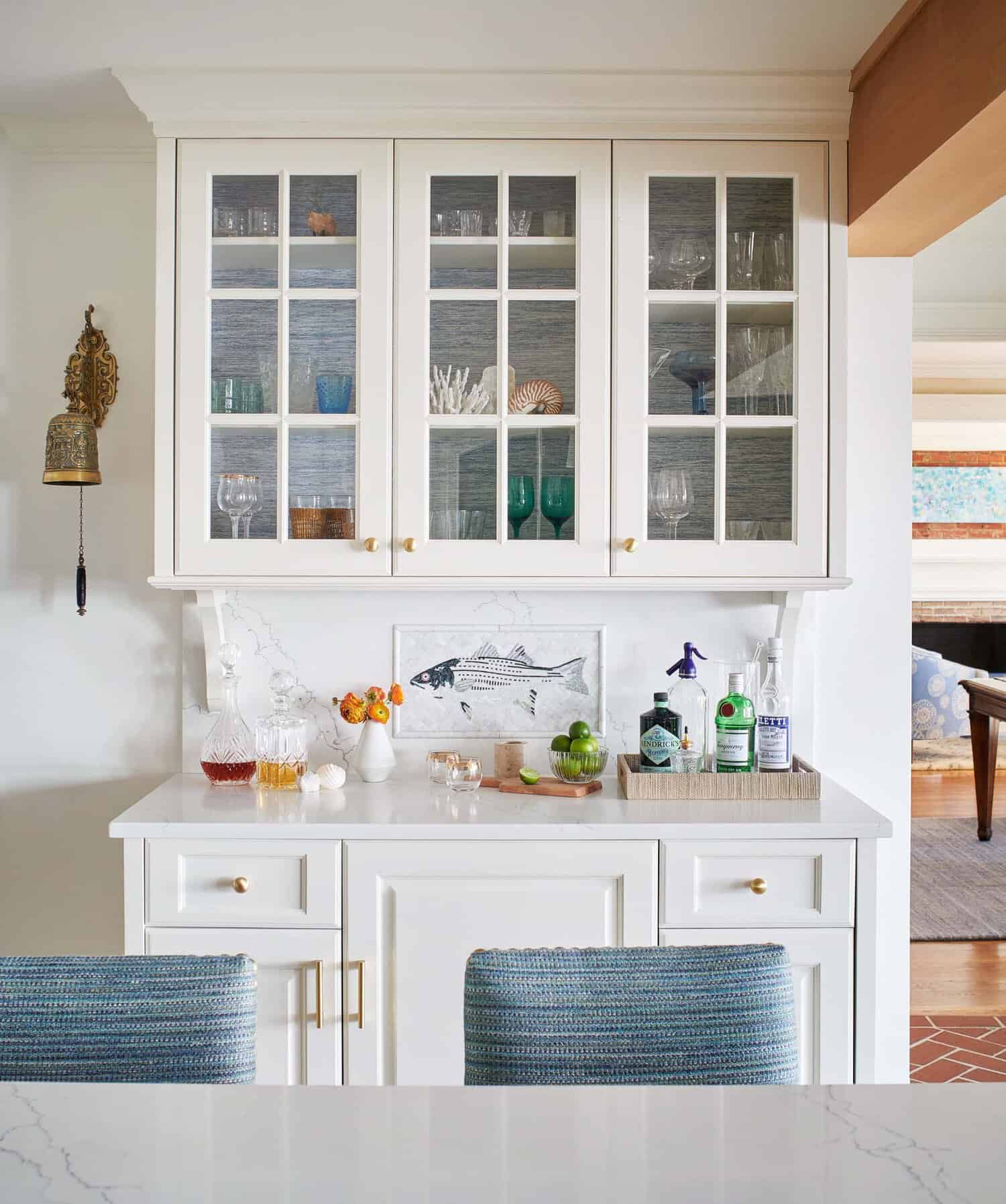 Built-in bar cabinet with glassware and fish mosaic backsplash