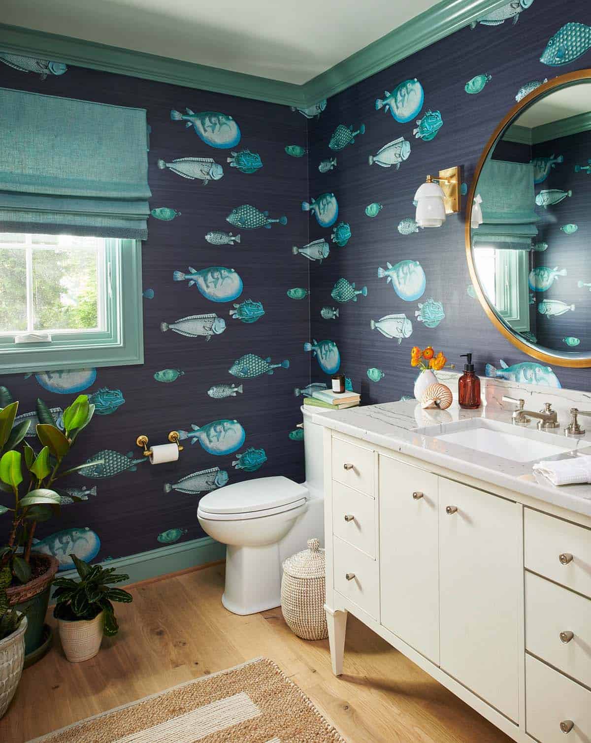 Powder room with navy fish-print wallpaper and teal trim
