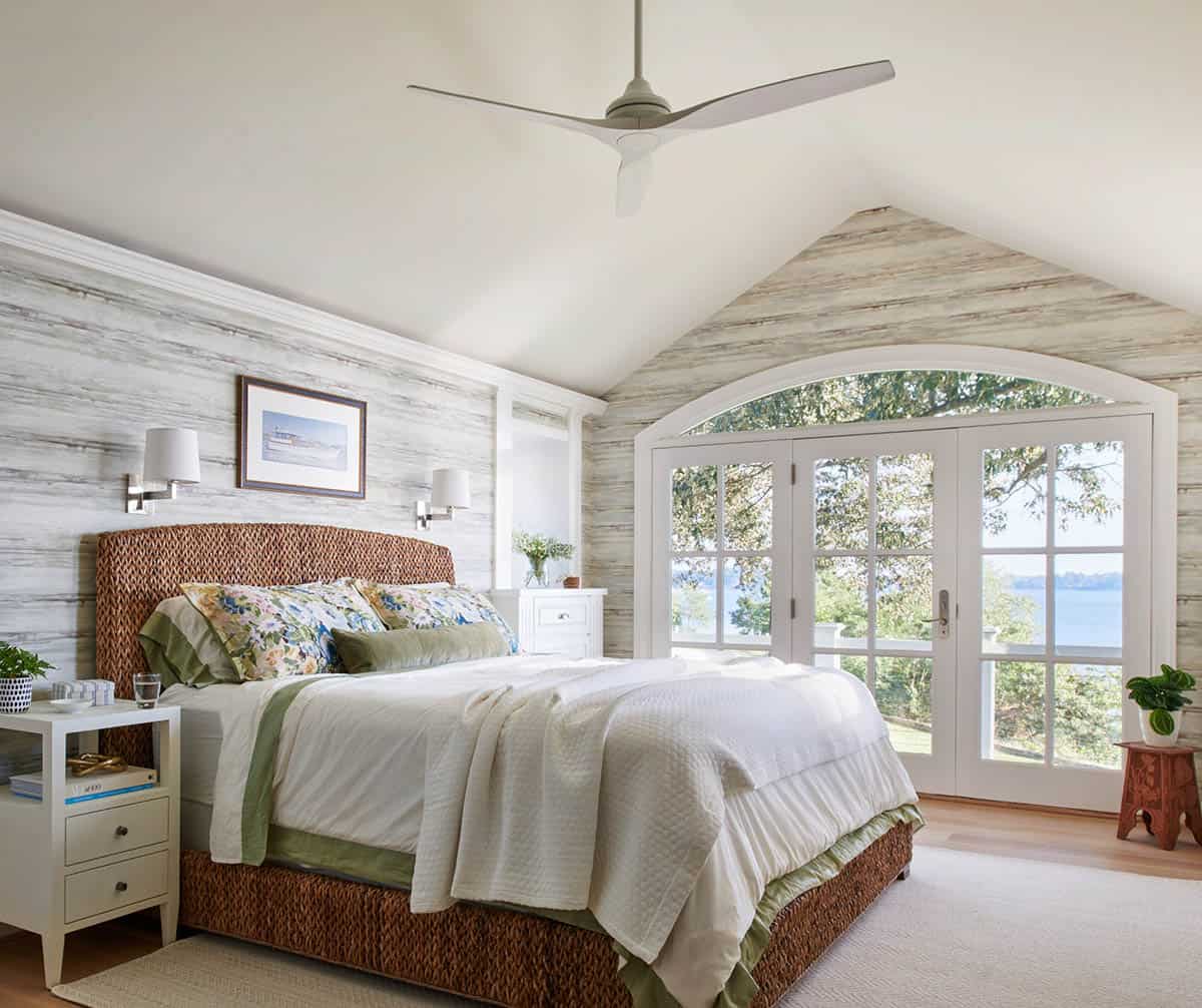Bedroom with woven headboard and arched doors to river view
