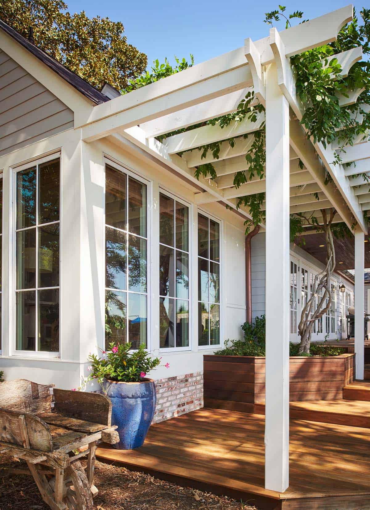 Wisteria-covered pergola over back deck seating area