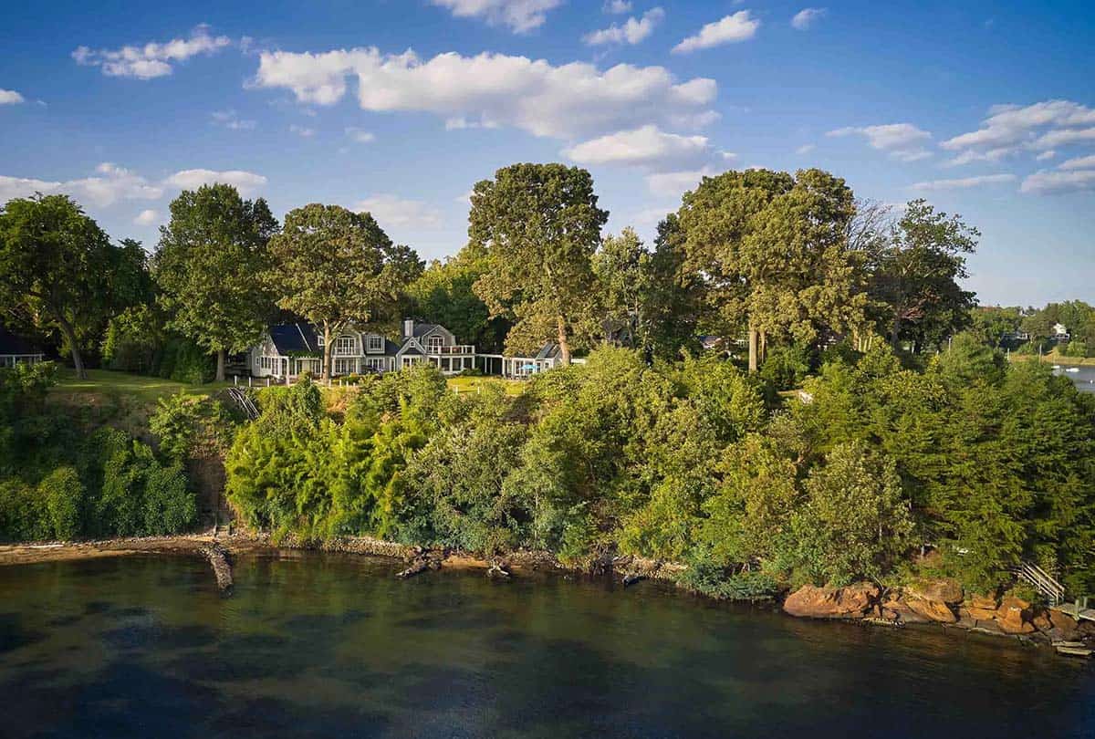 Aerial view of the riverfront property tucked into the wooded shoreline