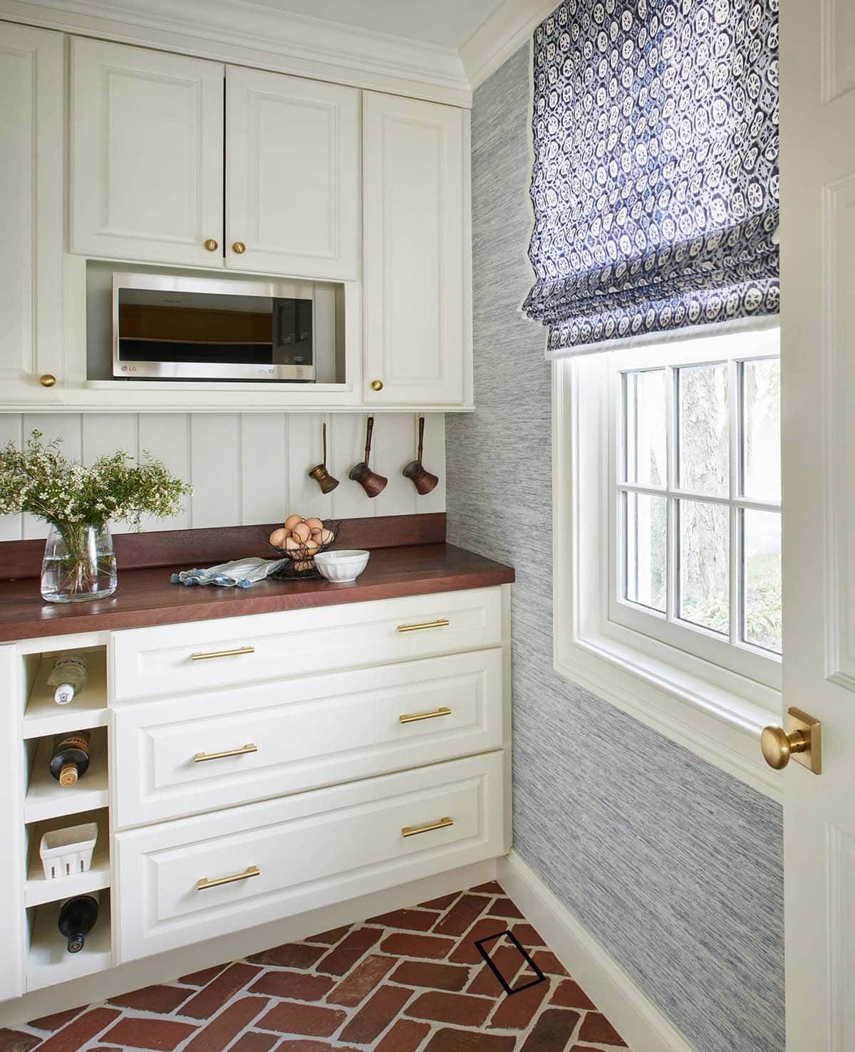 Butler's pantry counter with wine storage and floral roman shade