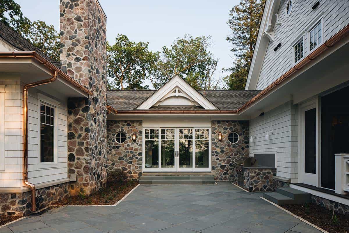 Stone-clad courtyard entrance with French doors and outdoor grill station