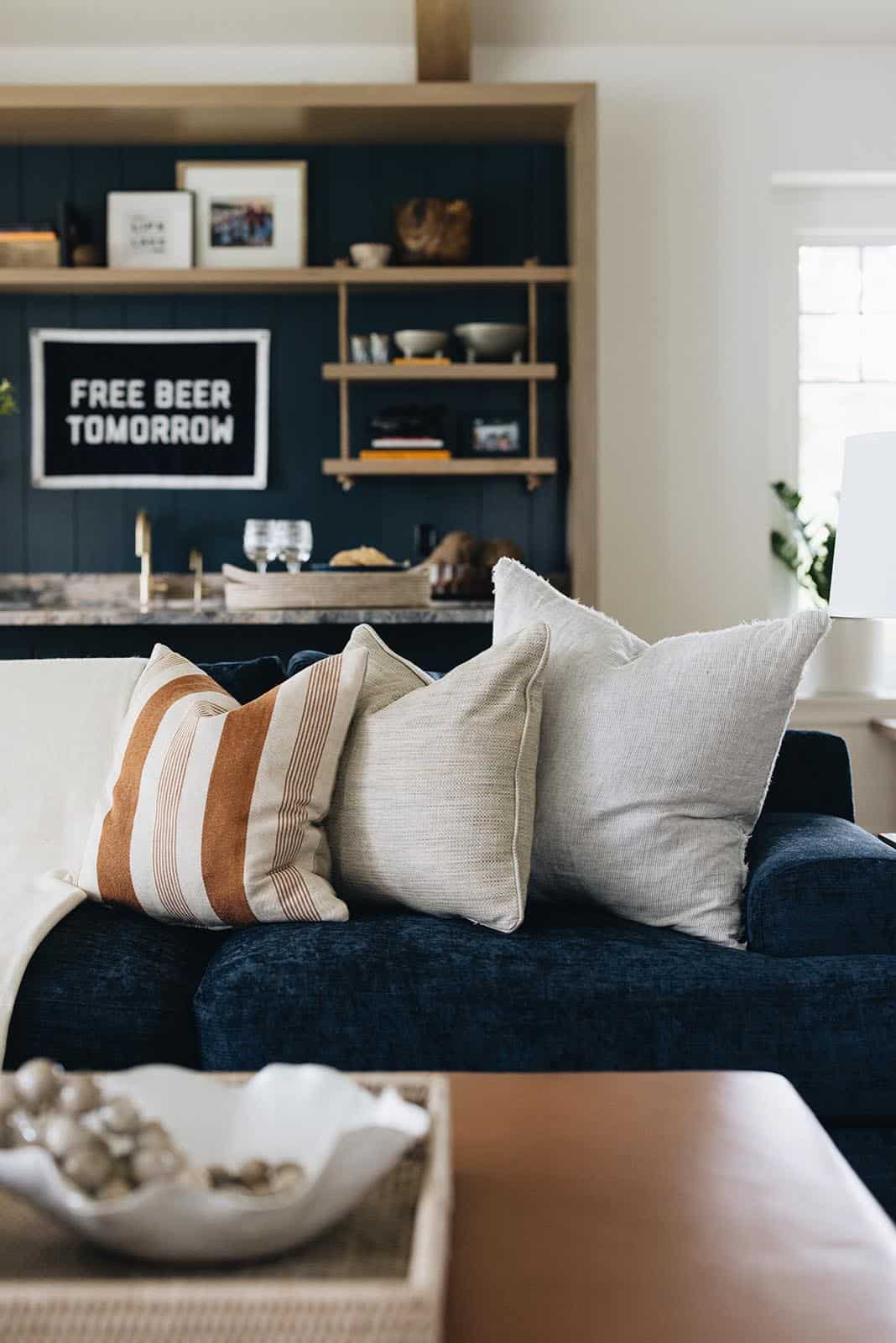Navy velvet sofa with striped and textured throw pillows