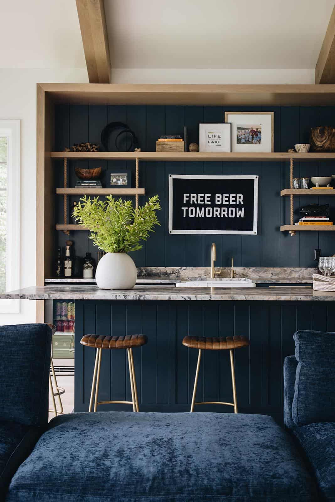 Wet bar with navy shiplap, marble counter, and "Free Beer Tomorrow" flag