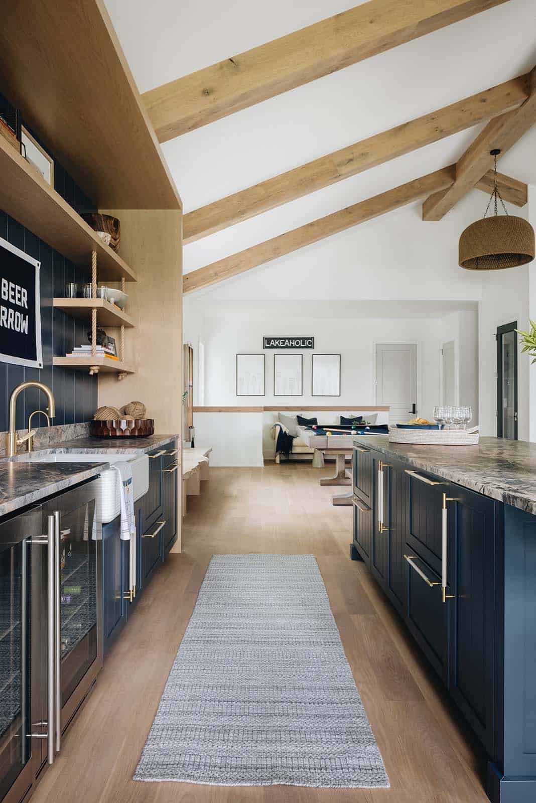 Vaulted great room with wood beams, navy island, and pool table beyond