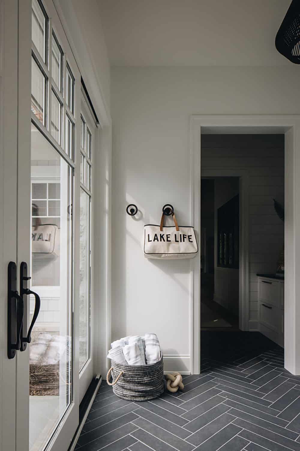 Mudroom entry with "Lake Life" tote bag and towel basket on herringbone tile