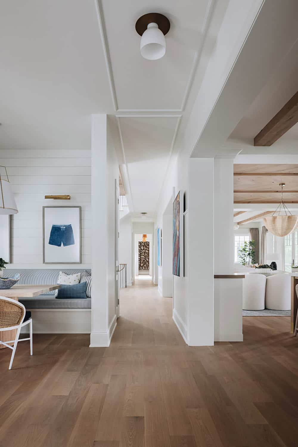 Open hallway connecting dining nook, gallery wall, and living room